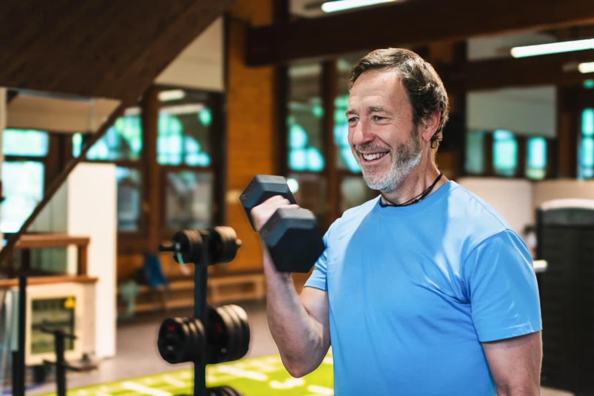 Woman smiling with dumbbells indoors